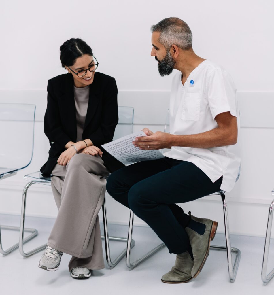 Clinician talking a patient through pre-treatment instructions in a relaxed consultation.