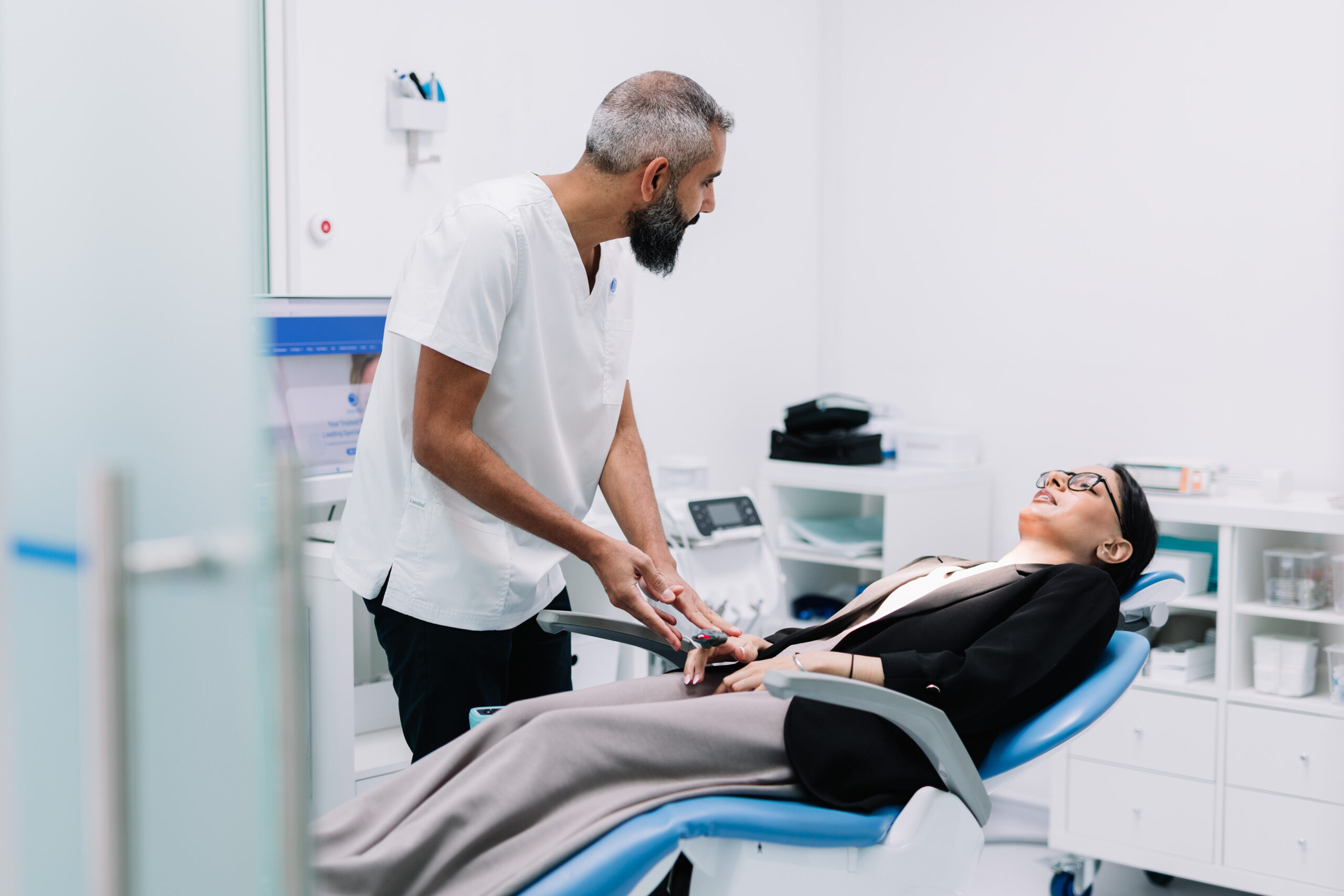 Anaesthetist preparing a patient for IV sedation in the dental chair.